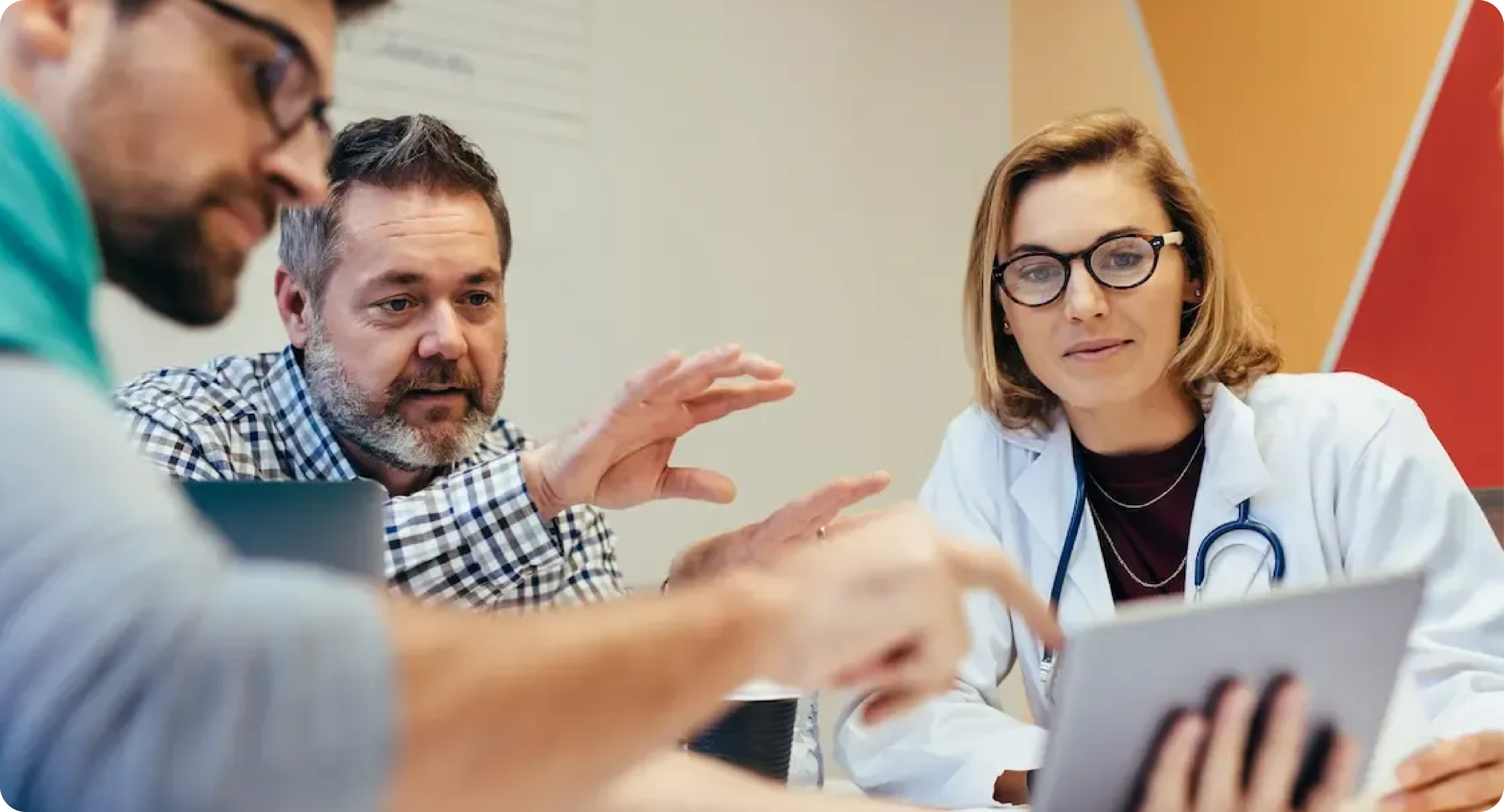 Médica y profesionales analizan un plan de salud en una mesa de trabajo.
